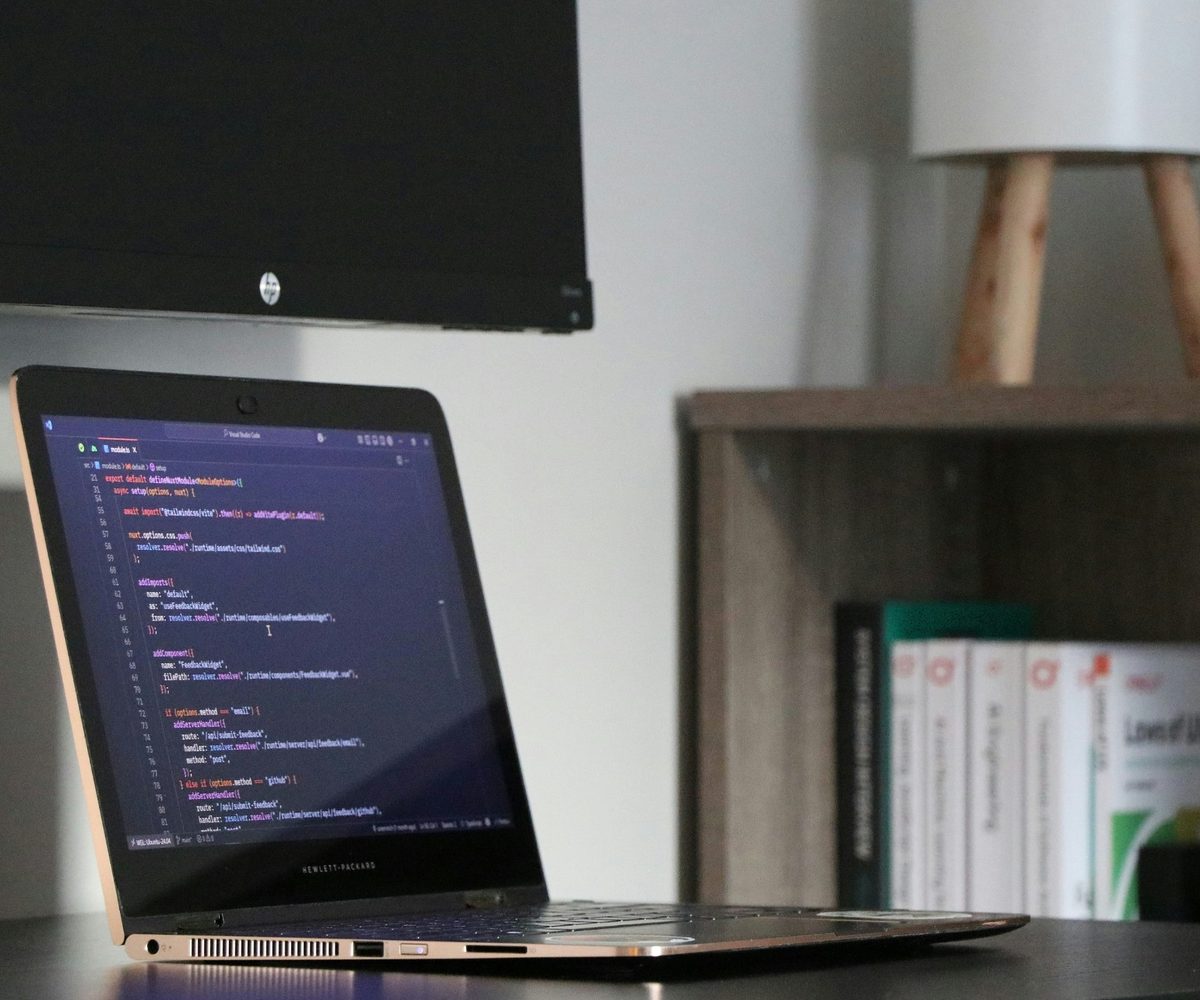 Laptop mit Quellcode auf einem Schreibtisch